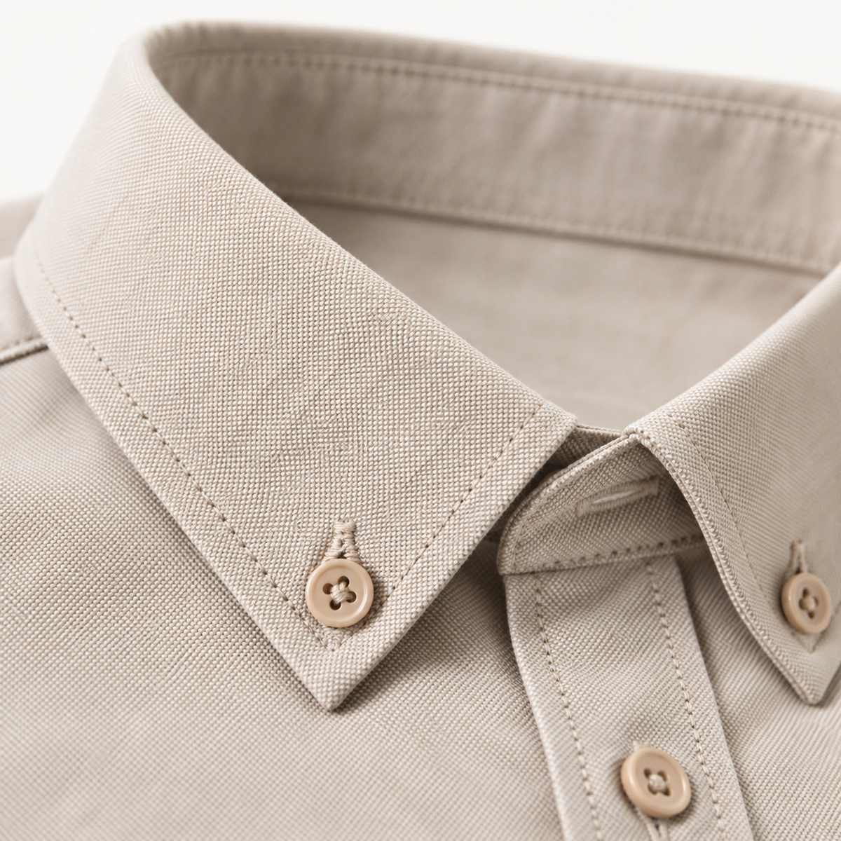 Close view of the button down collar and oxford weave on the taupe shirt