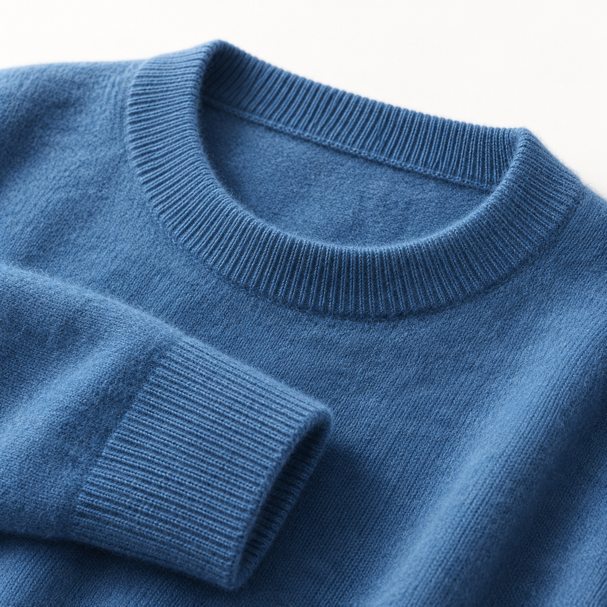 Close view of the ribbed collar and cuff on the haze blue wool sweater